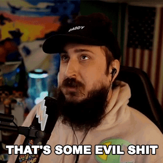 a man with a beard wearing a hat and ear buds says that 's some evil shit