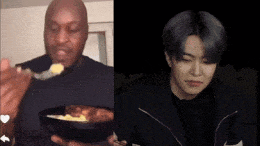 a man is eating a bowl of food with a spoon while another man looks on
