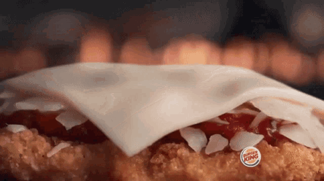 a close up of a burger king sandwich with cheese and ketchup