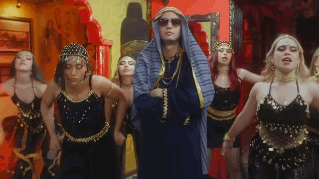 a man in a turban is surrounded by women in black