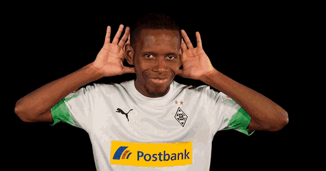 a man wearing a white shirt with a yellow postbank logo on it