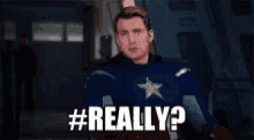 a man in a superhero costume is standing in a hallway and says `` really ? ''