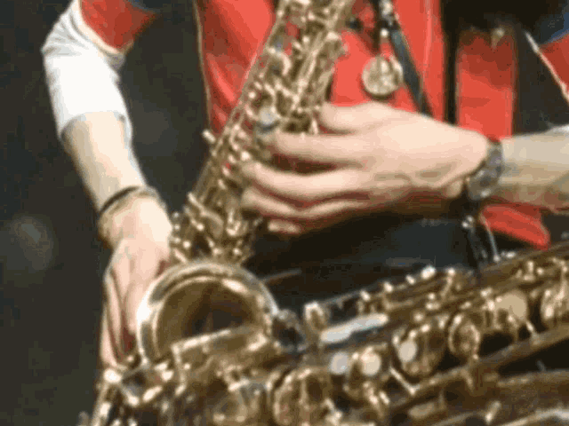 a close up of a person playing a saxophone with a watch on their wrist