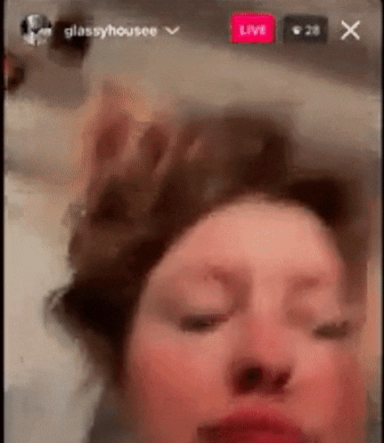 a close up of a woman 's face with her eyes closed and a red face .