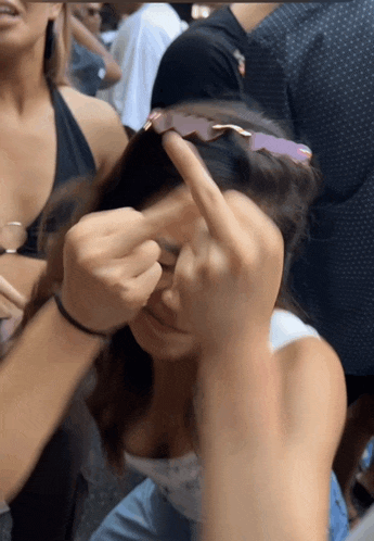 a woman wearing sunglasses is covering her face with her hand
