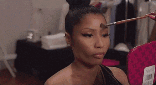 a woman is applying makeup to her forehead in front of a mirror .