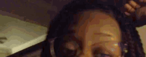 a close up of a woman 's face with dreadlocks on it .