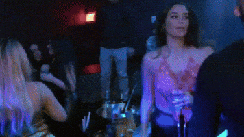 a group of people are dancing in a dark room