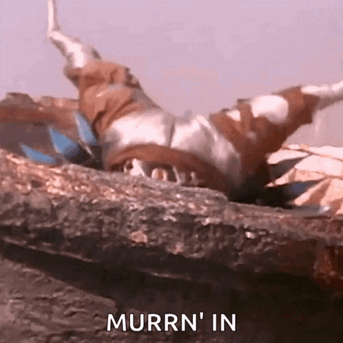 a power ranger is laying on his back on a rock with the words murrn ' in written on the bottom .