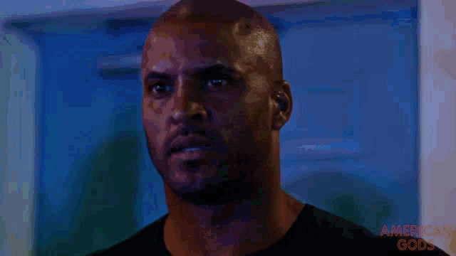a close up of a man 's face with the words american gods on the bottom left