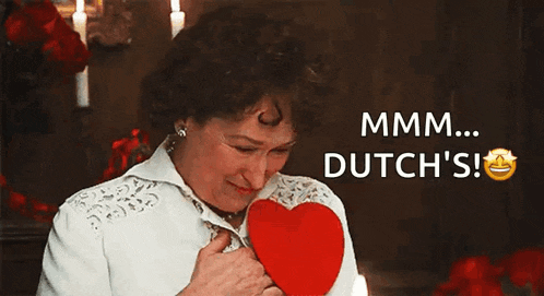 a woman is holding a red heart with the words mmmm dutch 's written above her