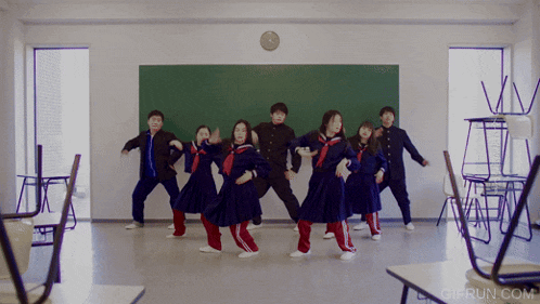 a group of children are dancing in front of a blackboard with the website gifrun.com in the corner