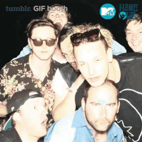 a group of young men are posing for a picture with a tumblr gif booth logo in the background