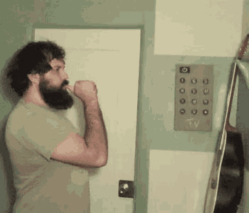 a man with a beard is brushing his teeth in front of an elevator button that says tv