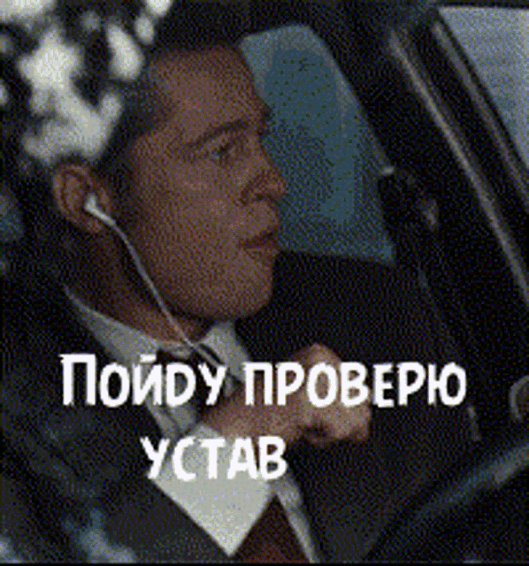 a man in a suit and tie is wearing ear buds while driving