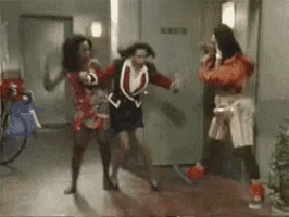 a group of women are dancing in a hallway in a room .