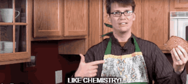a man in an apron holds a loaf of bread and says " like chemistry "