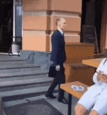 a man in a suit is walking down a set of steps