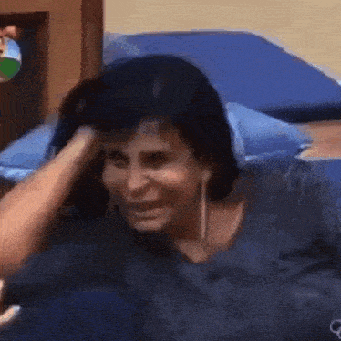 a woman is laying on a bed with her hand on her head and making a funny face .