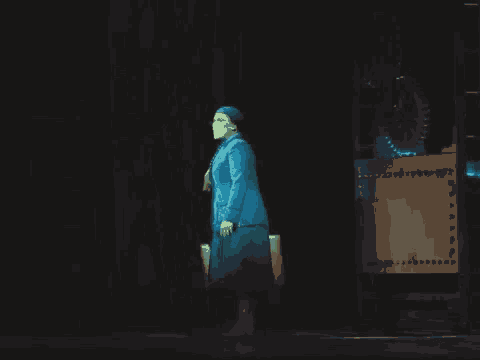 a woman in a blue dress stands on a stage