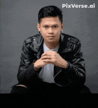 a man in a black leather jacket is sitting with his hands folded in front of a pixverse.ai logo