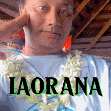 a man wearing a lei and a shirt that says iaorana