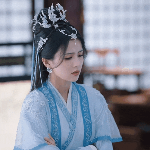 a woman wearing a blue and white dress and a crown on her head