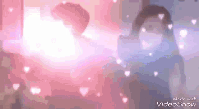 a woman is standing in front of a pink background with hearts coming out of it .