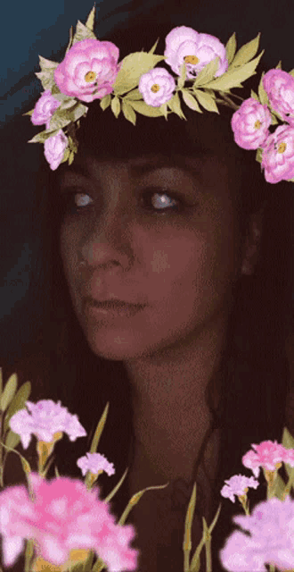 a woman with a flower crown on her head looks at the camera