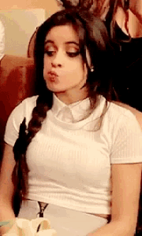 a woman in a white shirt is making a funny face