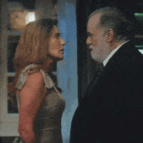 a man and a woman are looking at each other and the woman is wearing a dress
