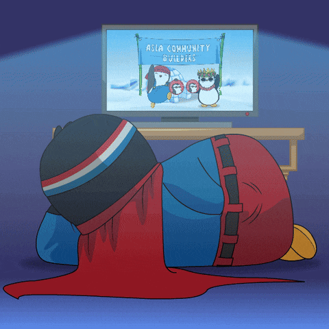 a cartoon of a penguin laying on the floor watching asia community builders on tv