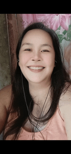 a woman wearing headphones and a pink tank top smiles