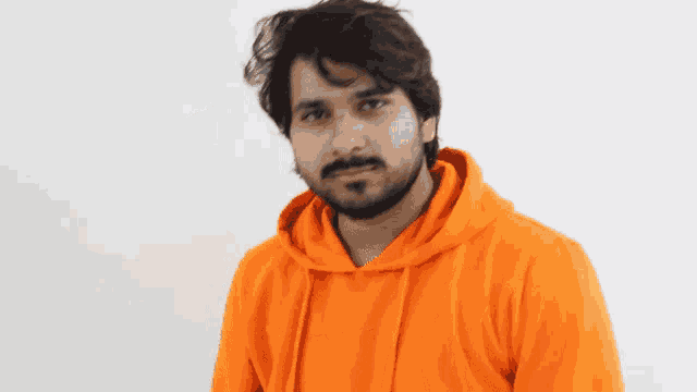 a man with a beard wearing a bright orange hoodie