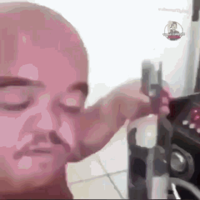a close up of a man 's face with his eyes closed while holding something in his hand .
