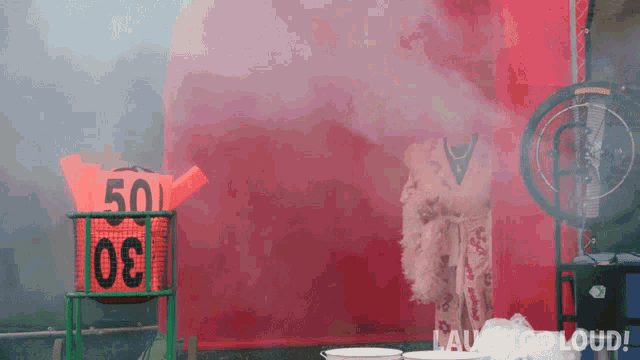 a man in a feather boa stands in front of a sign that says 50 on it