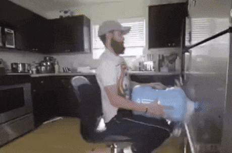 a man with a beard is sitting in a chair in a kitchen
