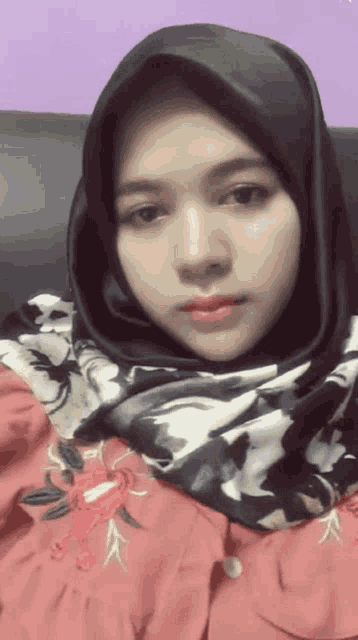 a woman wearing a black scarf and a red shirt