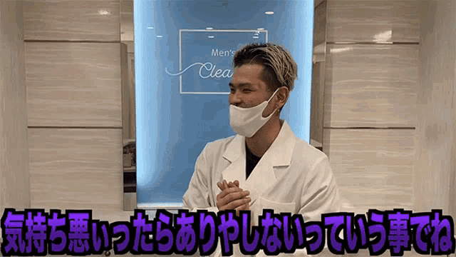 a man wearing a face mask stands in front of a sign that says men 's clear