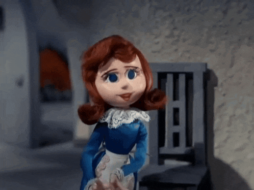 a doll with red hair and blue eyes is wearing a blue dress