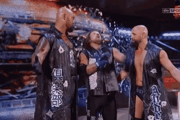 a group of wrestlers are standing next to each other on a wrestling ring .