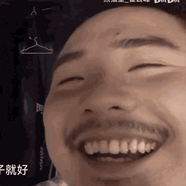 a man with a beard is smiling in front of a hanger that has everlast written on it