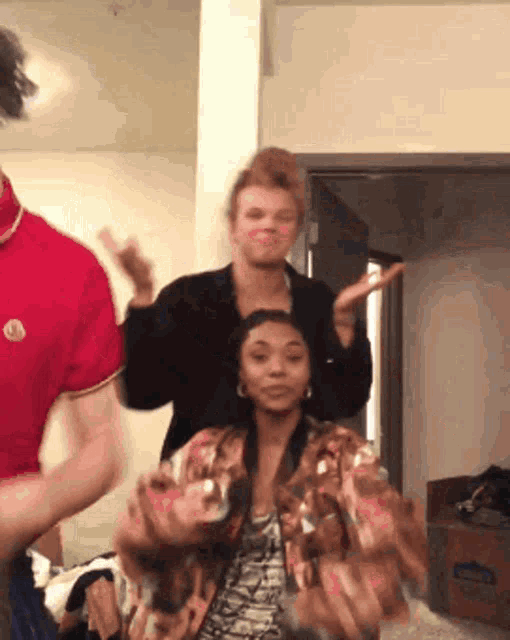 a group of people are dancing in a room and one of them is wearing a red shirt with the letter m on it