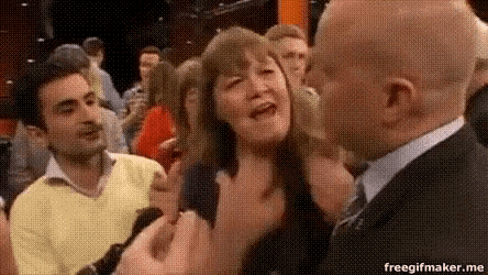 a man in a suit is talking to a woman who is crying in a crowd .