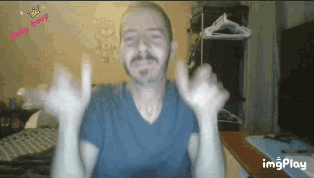 a man in a blue shirt is giving a thumbs up with the words baby boop behind him