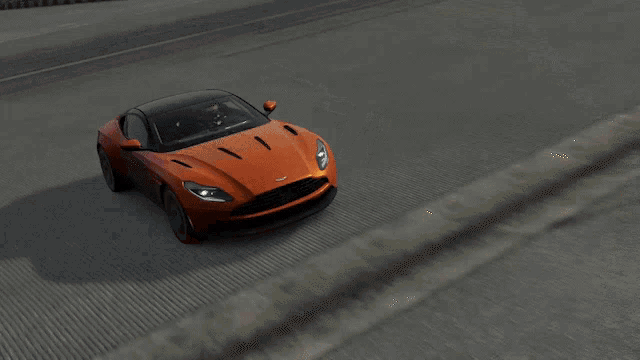 an orange car with a black roof is driving on a road