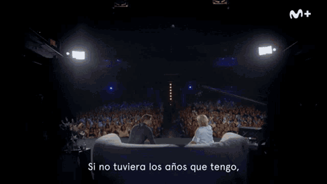 a man and a woman are sitting on a couch and the woman says no me frenaria in spanish
