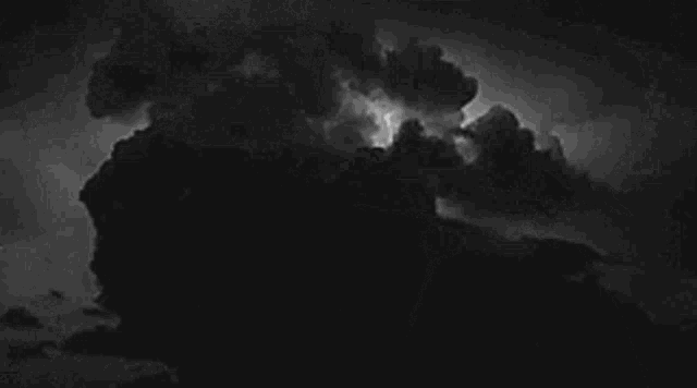 a black and white photo of a storm with lightning coming out of the clouds .