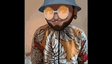 a man with a beard and sunglasses is wearing a bucket hat and a hawaiian shirt .