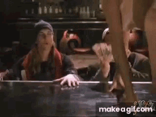 a woman in a bikini is dancing in front of a man in a beanie .